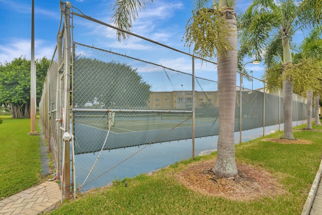 view of sport court featuring a lawn