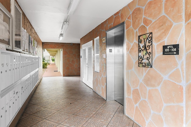 hallway featuring a mail area and elevator