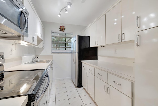 kitchen with light tile patterned flooring, stainless steel appliances, sink, and white cabinets