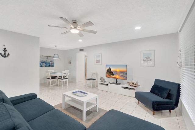 tiled living room featuring a textured ceiling and ceiling fan