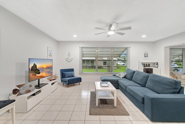 tiled living room featuring ceiling fan and a textured ceiling