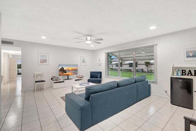 tiled living room with ceiling fan and a textured ceiling