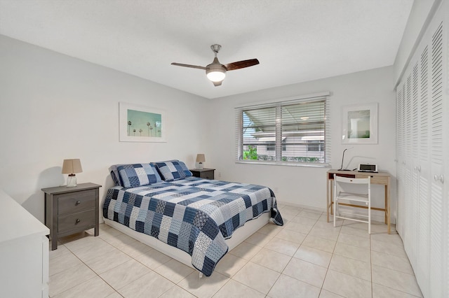 bedroom featuring light tile patterned floors, ceiling fan, and a closet