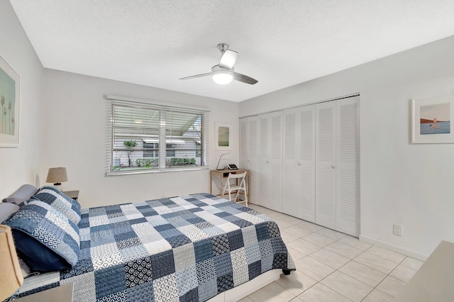 bedroom with light tile patterned floors, a textured ceiling, ceiling fan, and a closet