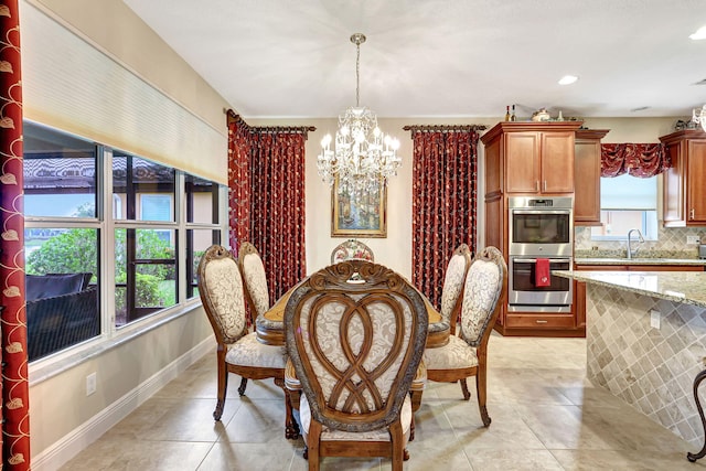 tiled dining space featuring sink and a chandelier