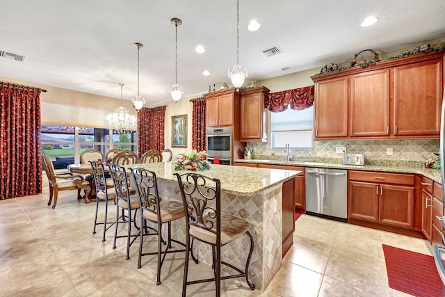 kitchen with a kitchen island, appliances with stainless steel finishes, and hanging light fixtures