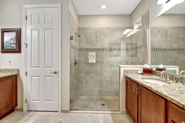 bathroom featuring walk in shower and vanity