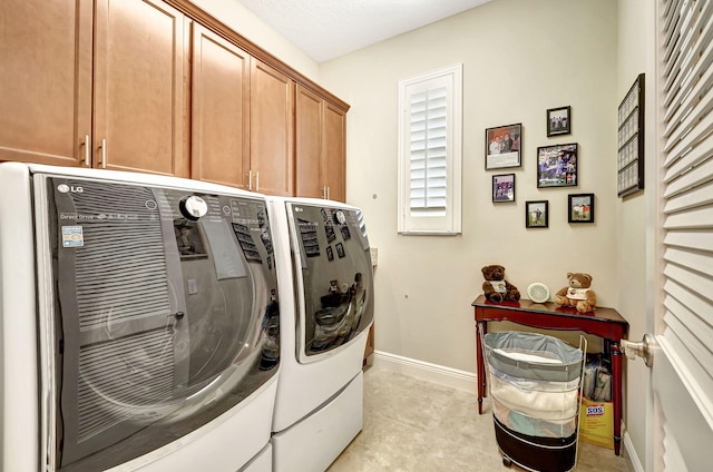 laundry room featuring cabinets and washer and dryer