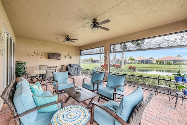 exterior space featuring a water view, ceiling fan, outdoor lounge area, and area for grilling