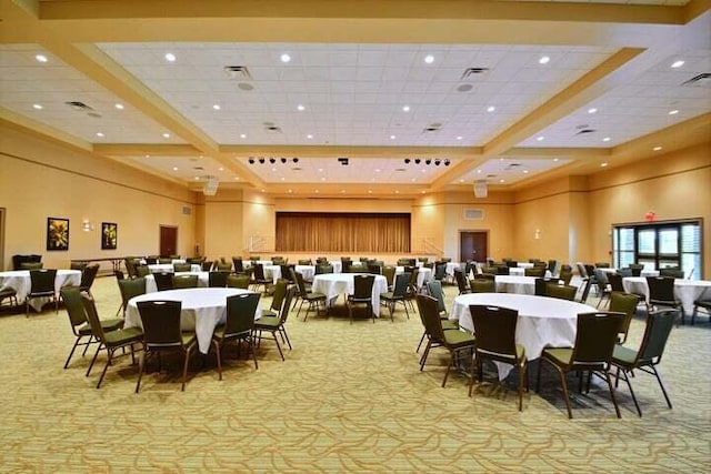 carpeted dining area featuring a paneled ceiling and a high ceiling