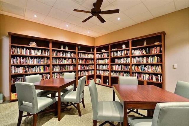 interior space featuring ceiling fan and a drop ceiling