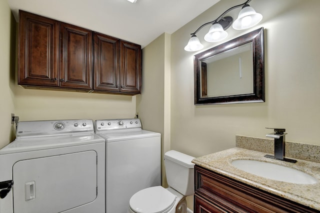 bathroom featuring washing machine and dryer, vanity, and toilet