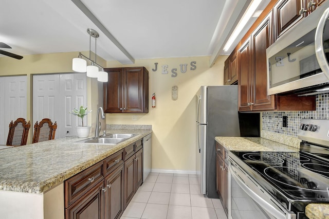 kitchen featuring sink, light tile patterned floors, appliances with stainless steel finishes, backsplash, and hanging light fixtures