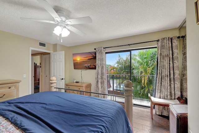 bedroom with dark hardwood / wood-style floors, a textured ceiling, and ceiling fan