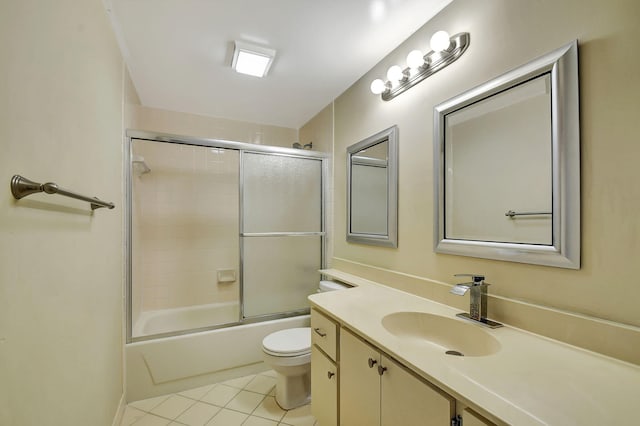 full bathroom featuring vanity, bath / shower combo with glass door, tile patterned floors, and toilet