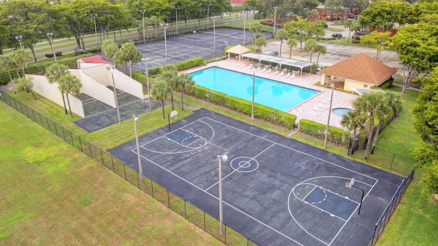 view of sport court featuring a fenced in pool and a lawn