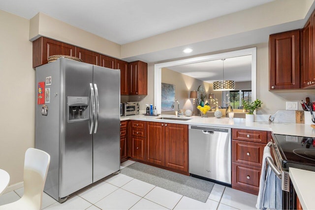 kitchen featuring hanging light fixtures, stainless steel appliances, sink, and light tile patterned flooring