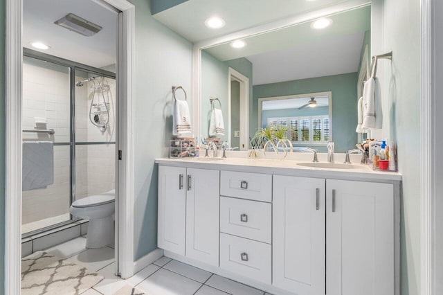 bathroom featuring a shower with shower door, vanity, ceiling fan, toilet, and tile patterned floors