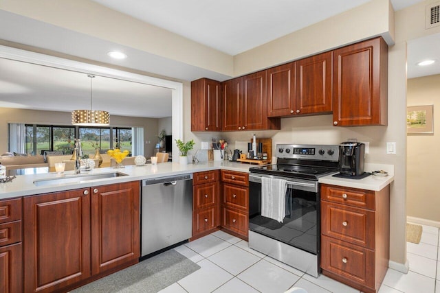 kitchen featuring sink, decorative light fixtures, light tile patterned floors, and appliances with stainless steel finishes