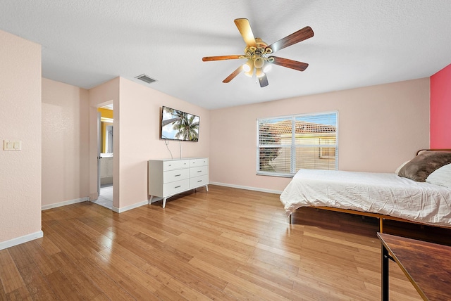 bedroom featuring ceiling fan, a textured ceiling, and light wood-type flooring