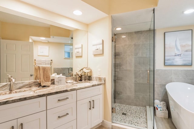 bathroom featuring independent shower and bath and vanity