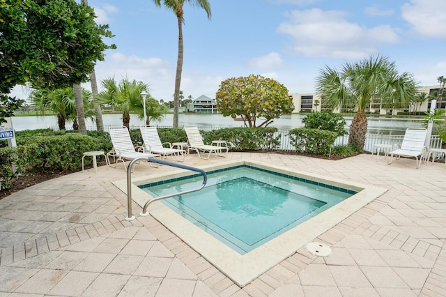 view of pool featuring a patio area and a water view