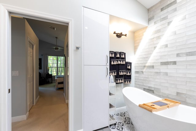 bathroom with ceiling fan and a tub to relax in