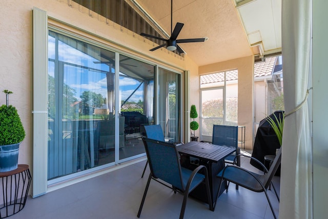 sunroom with ceiling fan and vaulted ceiling