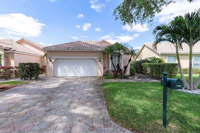 mediterranean / spanish-style house with a garage and a front lawn