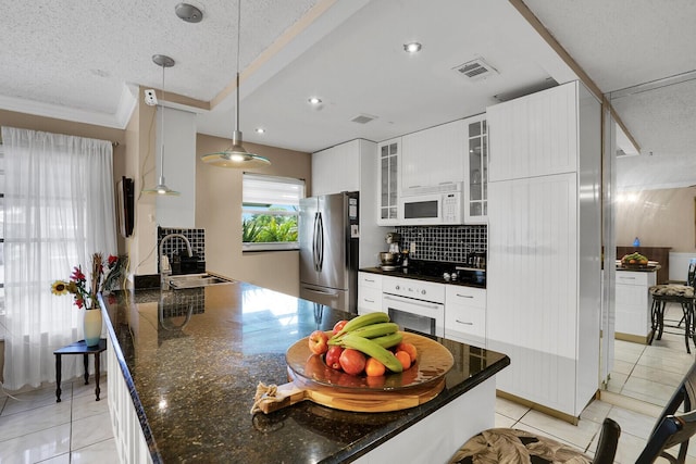 kitchen with white cabinetry, hanging light fixtures, white appliances, and sink