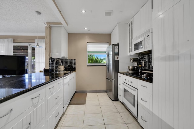 kitchen featuring sink, hanging light fixtures, light tile patterned floors, white appliances, and white cabinets