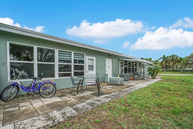 rear view of house featuring a patio, a yard, and cooling unit