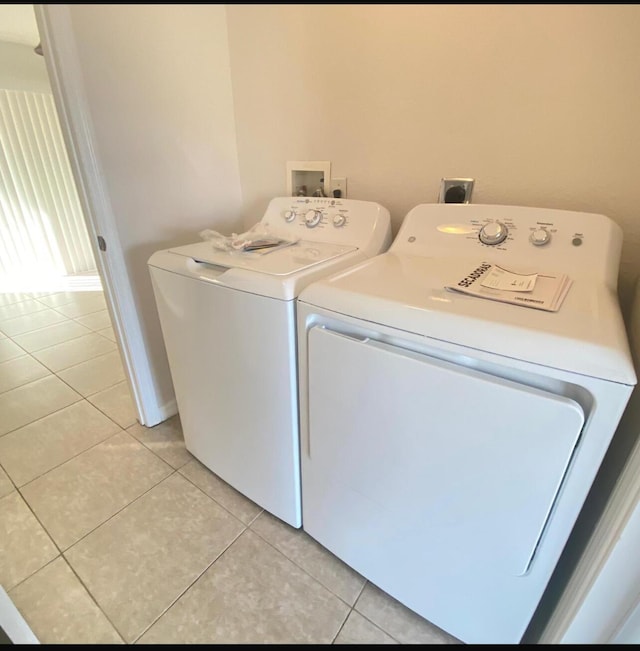 clothes washing area with light tile patterned flooring and independent washer and dryer