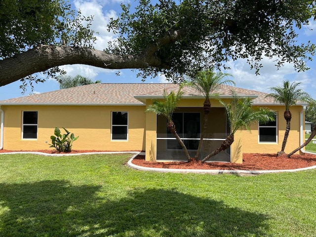 back of house featuring a sunroom and a yard