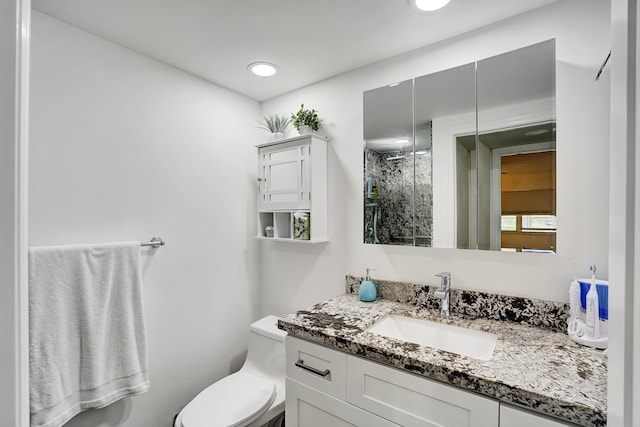 bathroom featuring vanity, walk in shower, and toilet