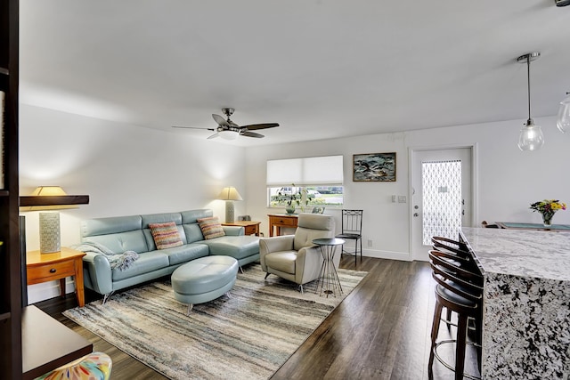 living room with ceiling fan, plenty of natural light, and dark hardwood / wood-style flooring