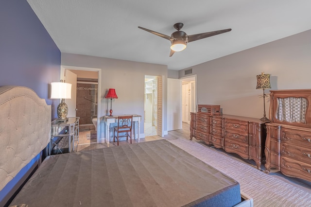 bedroom featuring a spacious closet, connected bathroom, ceiling fan, and a closet