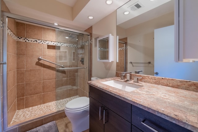 bathroom with an enclosed shower, vanity, tile patterned floors, and toilet