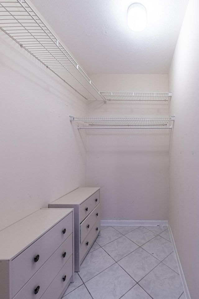 spacious closet with light tile patterned floors