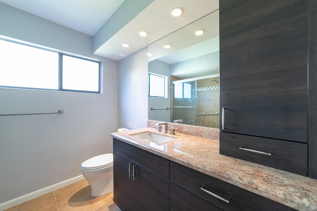 bathroom with tile patterned flooring, vanity, a wealth of natural light, and a shower with shower door