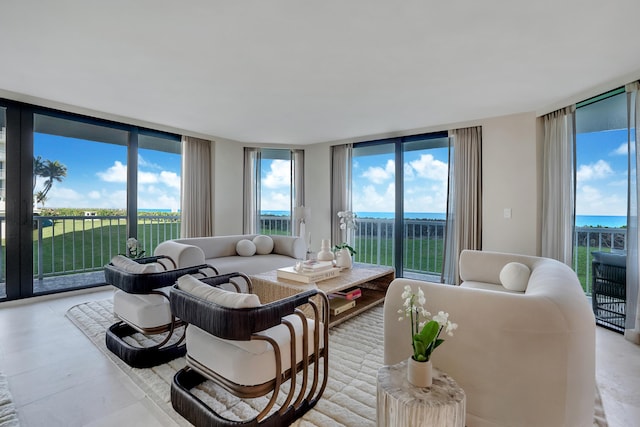 living room with a water view, floor to ceiling windows, and plenty of natural light