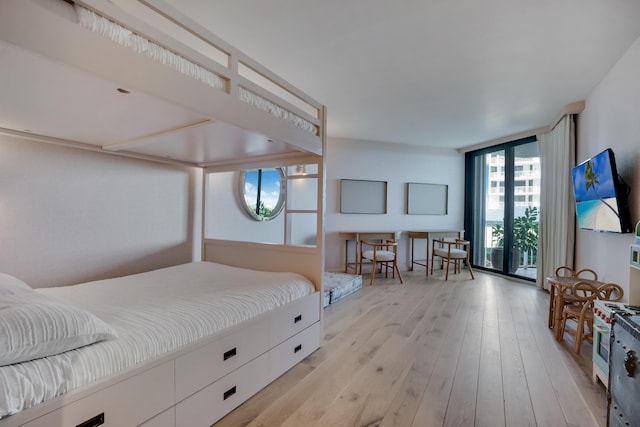 bedroom featuring expansive windows and light wood-type flooring