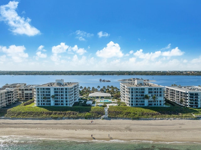 birds eye view of property with a water view and a view of the beach