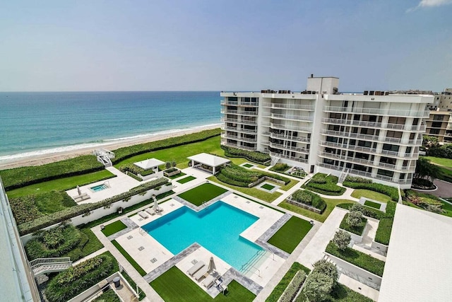 view of swimming pool featuring a view of the beach and a water view