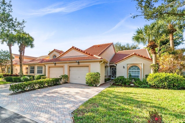 mediterranean / spanish-style house with a garage and a front yard