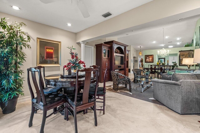 dining room featuring ceiling fan with notable chandelier and decorative columns