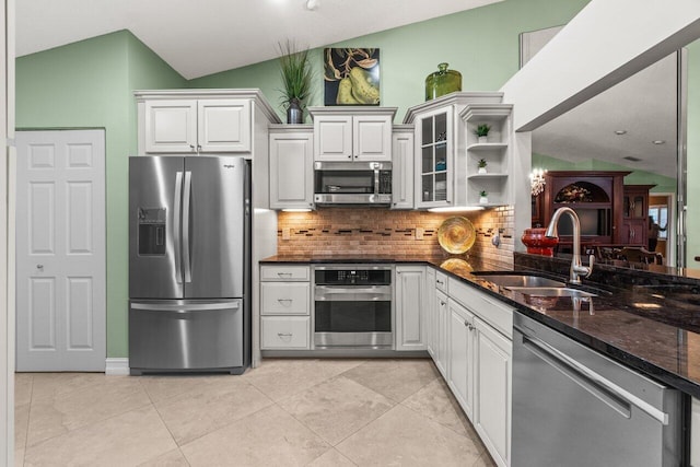 kitchen featuring lofted ceiling, appliances with stainless steel finishes, sink, and white cabinets