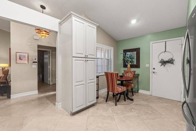 tiled dining space with vaulted ceiling