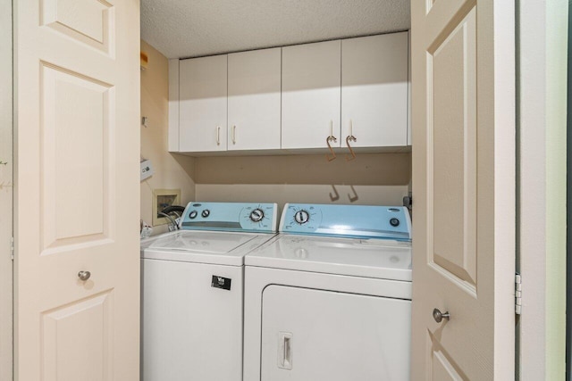 laundry room with cabinets, independent washer and dryer, and a textured ceiling