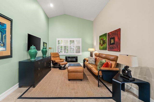 living room with a fireplace and high vaulted ceiling